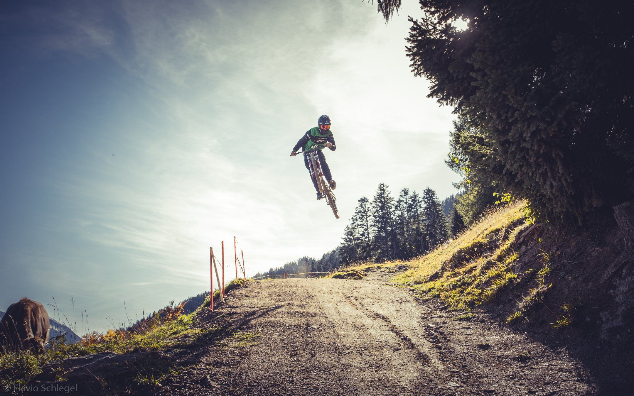 Rider im hohen Sprung über dem Trail vor Bergpanorama