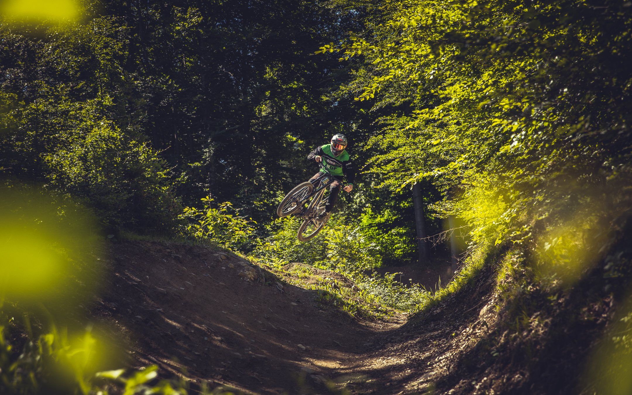 Rider auf einem Anlieger im sonnigen Wald am Brambrüesch