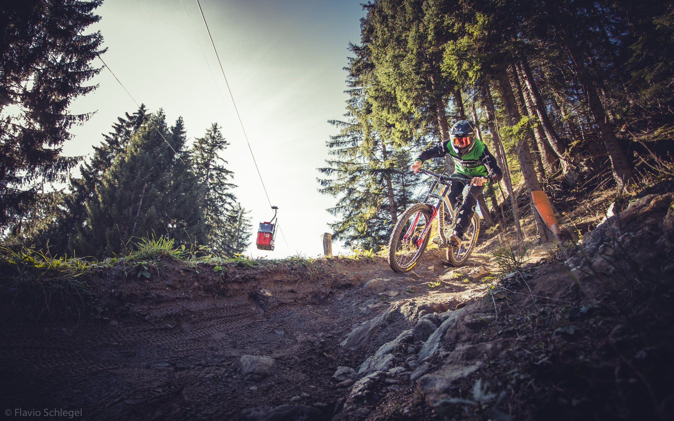 Rider auf dem Trail, im Hintergrund eine Gondel der Brambrüeschbahn