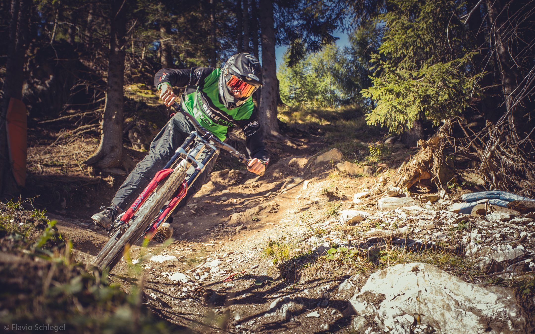 Downhill-Rider in einer Steinpassage mit Staubwolke