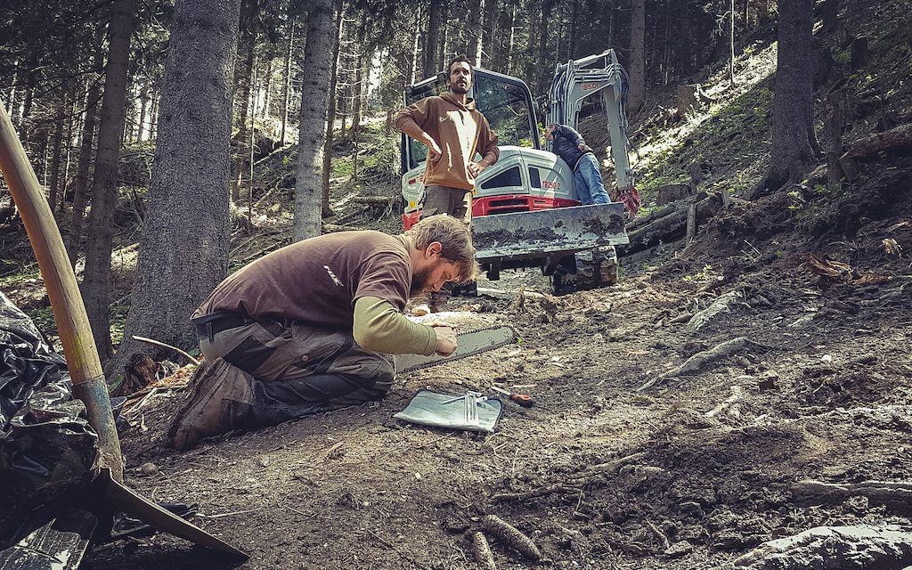 Volunteer schaufelt an einem Trail im Wald