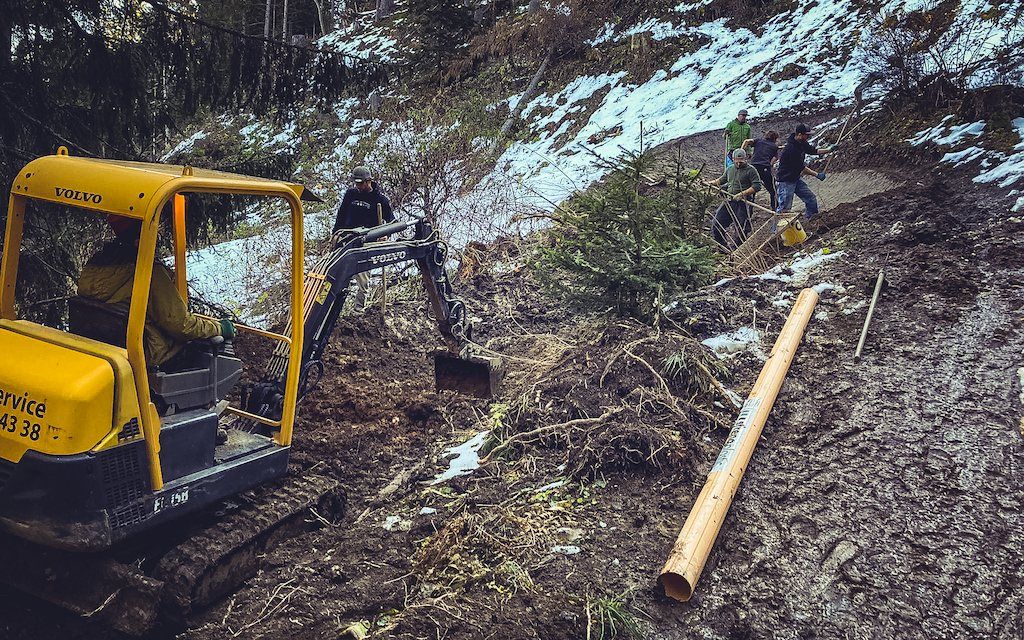 Volunteers mit Bagger beim Trailbau im Frühling
