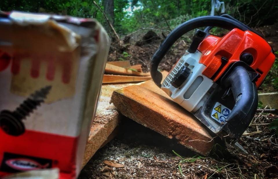 Motorsäge und Holz beim Trailbau